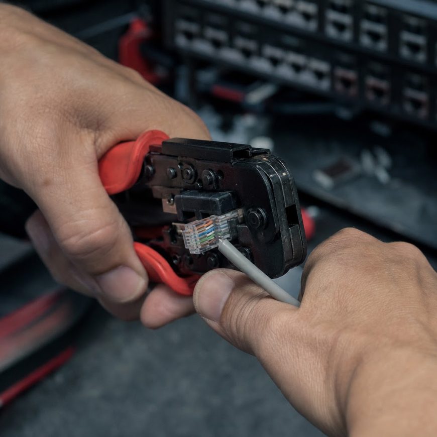 Detail rúk krimpujúcich RJ45 konektor na sieťový kábel